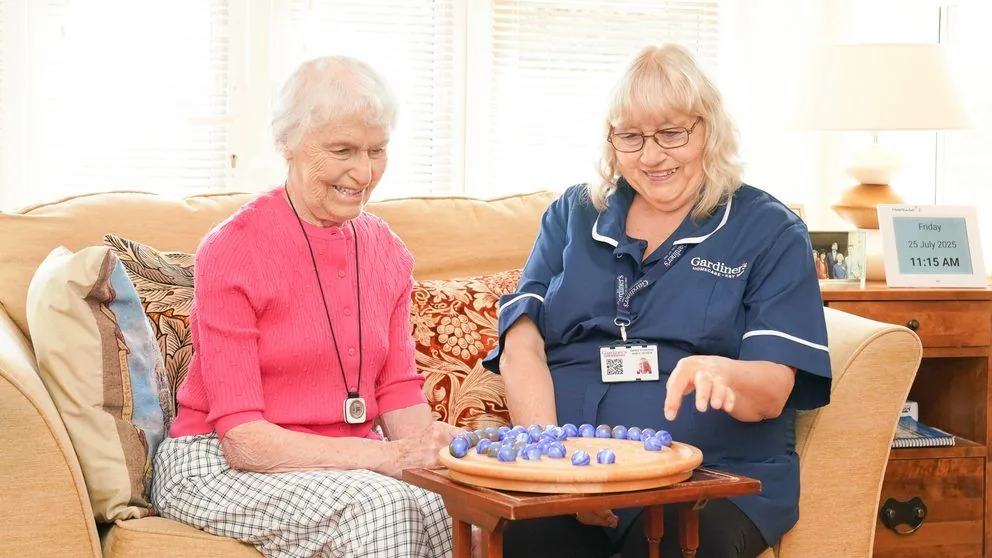 Carer playing a board game with a client