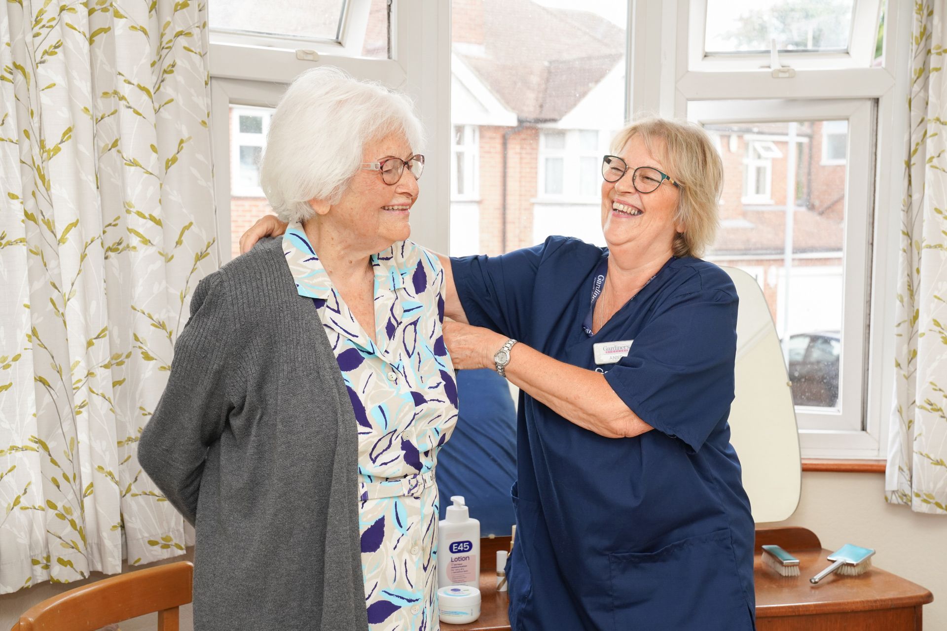 A Gardiner's carer helping a client get dressed at home