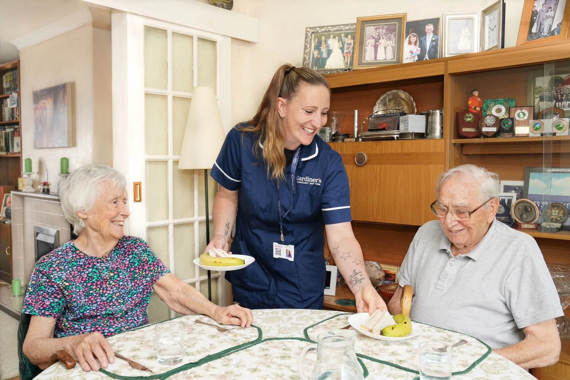 A carer serving lunch to a couple at home